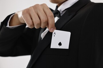 Illusionist taking playing card out of pocket on white background, closeup