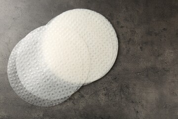 Edible rice paper sheets on grey textured table, flat lay. Space for text
