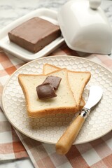 Sandwiches with chocolate butter and knife on table, closeup