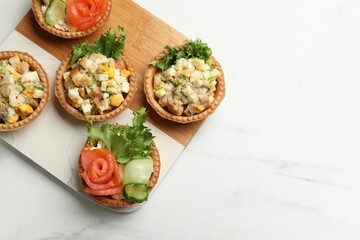 Tartlets with delicious fillings on white table, top view. Space for text