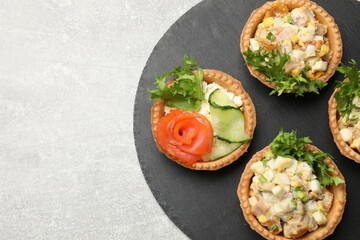 Tartlets with delicious fillings on grey table, top view. Space for text