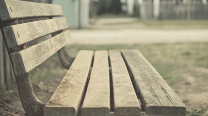 Fototapeta premium Weathered wooden park bench outdoors, shallow depth of field.