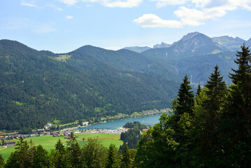 Picturesque view of the valley and lake under the mountain. Natural landscape and tourist hiking spot. Top view