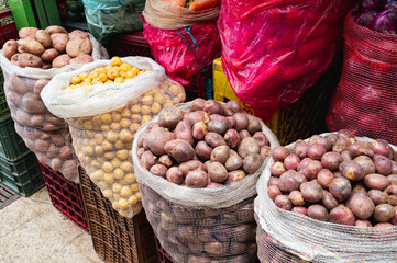 Sacks of fresh, colorful potatoes at a farmers market.