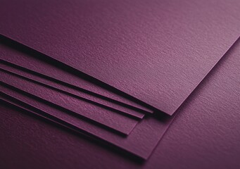 Close-up view of a stack of dark purple textured paper sheets, creating an elegant and sophisticated backdrop perfect for various design projects and artistic endeavors