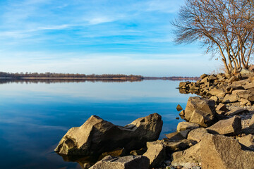 Rocky bank of a large river. Stones strengthen the bank of a wide river