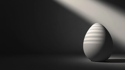 Single grey egg illuminated by a spotlight in a dark room.
