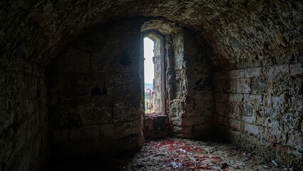 Obraz premium Eerie castle dungeon interior with blood smeared slit window