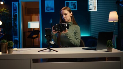 Gen Z tech expert filming sponsored content, unboxing newly released VR glasses product to make viewers buy it. Influencer presenting virtual reality headset product to audience, camera B