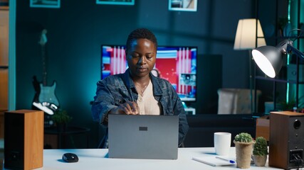 Woman arriving in apartment office, sitting down at desk, opening laptop to begin doing tasks....