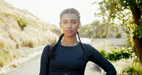 Portrait, outdoor and woman with fitness, wellness and training with challenge, pride and endurance. Face, healthy person and runner in street, practice and workout with nature, serious and progress