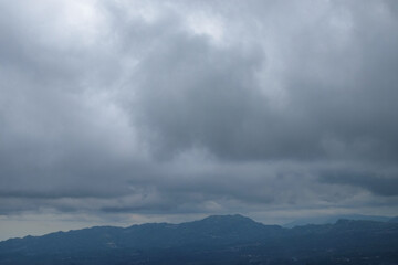 Dramatic dark blue clouds with abstract texture over valleys and hills.Natural view of hills.Climate and weather concept.For graphic design or banner background