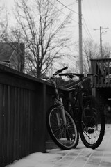 Obraz premium Bicycles Resting by Snow-Dusted Wooden Railing in Winter Scene