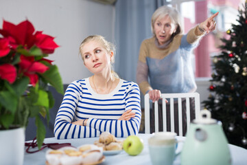 Elderly mother quarreling with daughter during christmas time at home