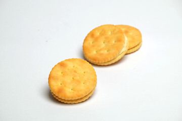 Cracker biscuits with butter and cream seasoning isolated on white background.  Sweet and crunchy taste.Snack food industry concept.Copy space for text.For graphic design or banner background