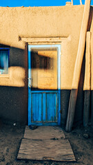 Rustic Adobe Home with Vibrant Blue Door and Shadows