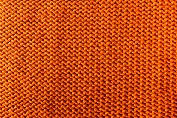 Obraz premium Texture of orange knitted fabric as background, top view.