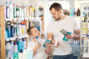 Buyers picked up oral care products. Dad and son took toothpaste, toothbrush, and mouthwash from...
