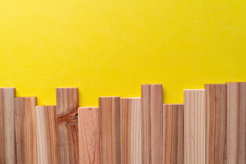 黄色背景に並ぶ木の板