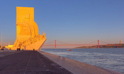 View of the 25th of April Bridge over the Tagus River and the city's waterfront at sunset in Lisbon, Portugal,