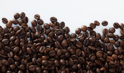 Natural background of roasted coffee beans on white surface..