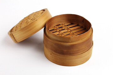 A traditional bamboo steamer with its woven lid placed beside it, showcasing natural texture and craftsmanship on a clean background.