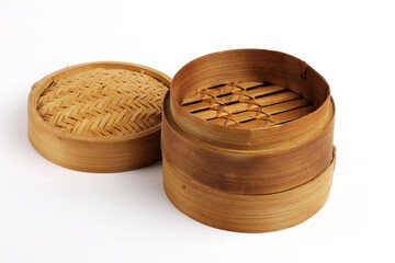 A handcrafted bamboo steamer with its woven lid beside it, showing natural texture and classic culinary design on a clean backdrop.