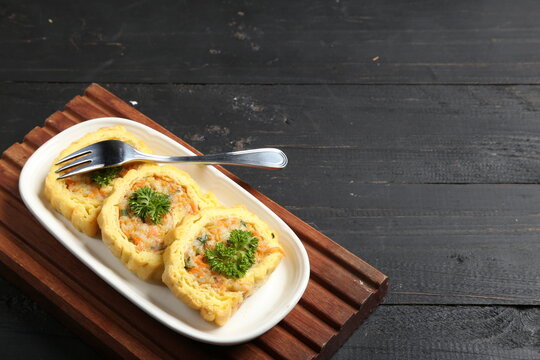 Vegetable egg roll, beef omellete korean, rolade daging ayam, street food with white plate, wooden tray on dark wooden background