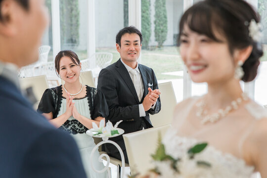 結婚式で拍手をして祝う笑顔のゲスト・出席者・参列者・友人の男女
