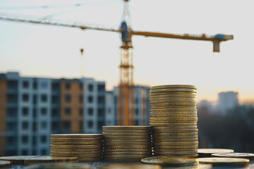 A large pile of assorted coins stacked on a flat surface showcasing various denominations and designs in a well-lit environment