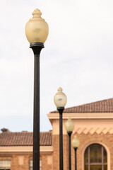 Historic lamp posts line a street outside of a historic building facade in downtown San Jose,...