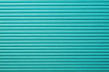 Obraz premium Long exposure photography reveals a textured turquoise background; close-up view showcasing horizontal corrugated paper lines.