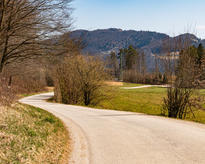 A winding road through a valley, above which hills rise.