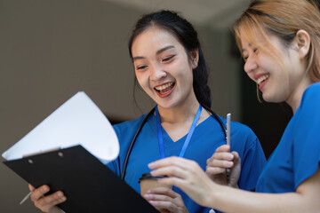Doctors sharing a light moment during a break, reviewing a clipboard.
