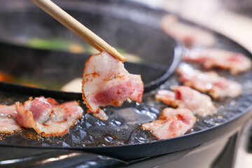 Party for barbecue japanese style, yakiniku. Meats are being cooked on stove frying pan