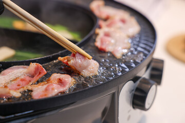 Party for barbecue japanese style, yakiniku. Meats are being cooked on stove frying pan