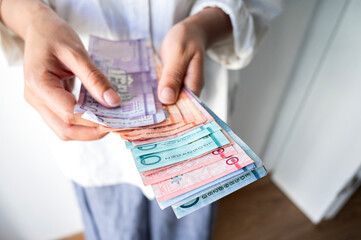 Closeup of hands with Dominican pesos