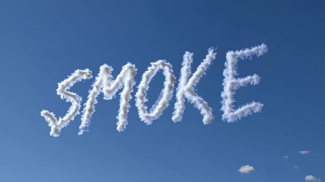 Skywriting displays the word 'SMOKE' against a clear blue sky, capturing the art of aerial messages. Wide-angle video shot from the ground up.
