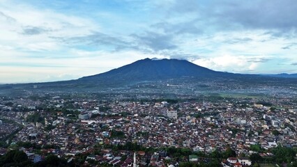 View of Puncak Bogor city with mountains in the background at dawn. Houses fill the foreground with...