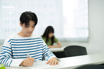 授業料のクラスで勉強するアジアのティーンエイジャー