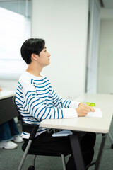 授業料のクラスで勉強しているアジアの 10 代の少年