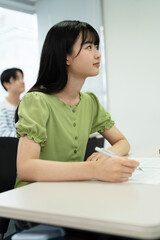 授業料のクラスで勉強するアジアのティーンエイジャー