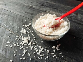 Salt in bowl on black wooden table background, Food ingredient 