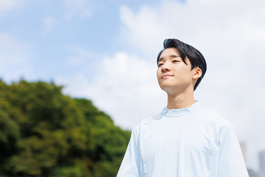 ナース服を着たアジアの10代の少年が前を向いている