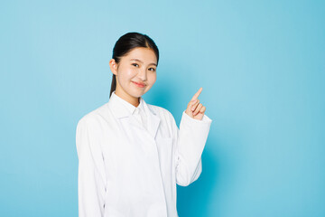 カメラに向かってポーズをとる白衣を着たアジアの 10 代の少女