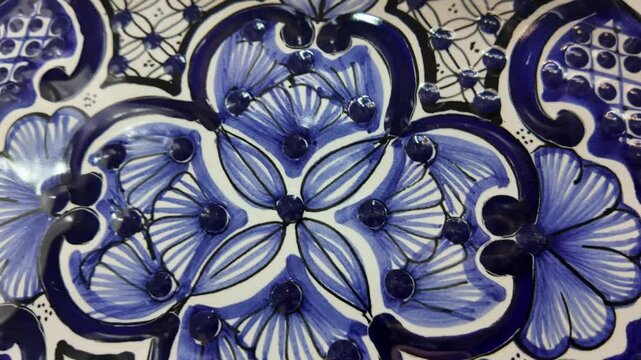 A blue and white tile with a flower design