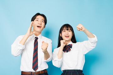 高校の制服を着たアジアのティーンエイジャーと応援のジェスチャー