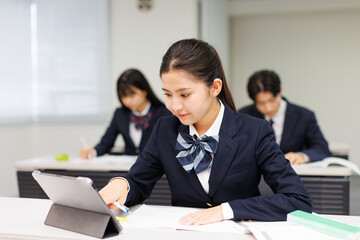 携帯電話を使って勉強するアジアの 10 代の少女