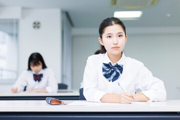 授業で勉強する高校の制服を着たアジアのティーンエイジャー