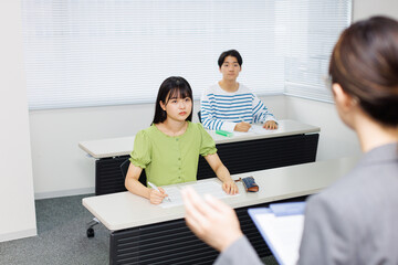 授業料のクラスで勉強するアジアのティーンエイジャー